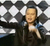A person in a black jacket with blue shoulder accents performs animated gestures against a black-and-white diamond-patterned background, captured in a sequence of frames showing motion.