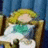 Pixelated anime-style character with blonde hair and green top, seated in wooden chair against blue background; white text overlay reads 'at 8:44:45' on right frame.