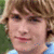 A pixelated image of a person with light brown hair and fair skin, next to blue text blocks reading 'Hey baby take a picture of me' followed by three heart symbols.