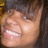 Pixelated close-up of a person's face with closed eyes, visible teeth, and light skin tone against dark background.