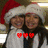 Two people wearing Santa hats and white coats stand close together, with red pixelated hearts over their chests in one view and the word 'sisters' in another.