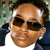 Static pixelated image of a person wearing dark sunglasses and a blue jacket over a white shirt, with visible facial features including eyes, nose, mouth, and ears.