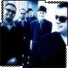 Group of people in dark suits with blue-toned background, some wearing sunglasses and caps, arranged in a -like composition
