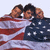 Two side-by-side frames of a pixelated animated icon showing four people wrapped in an American flag, with slight pose differences between frames.