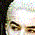 Pixelated close-up of a person's face with visible eyes and nose, set against a multicolored pixel grid background.