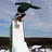 Animated sequence showing a figure in dark green attire atop a white pillar against a blue sky background.