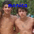 Two shirtless individuals stand outdoors with green foliage background; blue pixelated text reads 'monica is awesome' across the image.