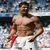 Two shirtless men in white shorts with red accents stand side-by-side in a stadium, with large text reading "GOAL!!!" overlaid on the right.