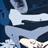 Pixelated static image of a figure in white clothing against dark blue background with light gray accents.