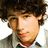 Pixelated image of a person with curly brown hair and light skin on left, pink background with dark blue text reading 'the hottest person... on the planet. NICK JONAS' on right.