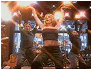 Britney Spears in a black strapless top with arms raised, then smiling while wearing a microphone headset.