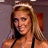 A woman with long blonde hair and a headband smiles while wearing a black halter top against a purple background.