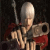 Pixelated figure with light-colored hair, red cape, and dark armor holding a sword against black background.