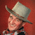 Pixelated static image of a person wearing a light gray conical hat with dark brown brim, red background, and partial clothing visible.