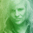 Pixelated green-toned image of a person's face with visible eyes, nose, and mouth against a gradient background.