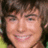 A four-quadrant image with a pixelated portrait of a smiling person with brown hair in the top-left, green pixelated text on blue backgrounds in the top-right and bottom-left quadrants, and a solid gray background in the bottom-right.