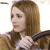 A pixelated image of a person with light brown hair wearing a white top and dark jacket against a plain background.