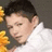 Pixelated close-up of a person with short dark hair wearing a white shirt, partially obscured by a yellow-orange floral pattern on the left.