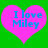 Two pink hearts on green background with blue text reading 'I love Miley' in pixelated font.