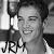 Black-and-white animated sequence showing a person with dark hair holding a microphone, smiling and transitioning from closed eyes to open eyes while text below changes from 'JRM' to 'JRM ?' then 'JRM ♥'.