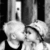 Black-and-white animation of two figures in a kiss pose with text overlay, set against vertical striped background.