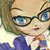 Pixelated close-up of a person with light skin, blue eyes, and dark-rimmed glasses wearing a blue top with white collar.