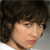 Pixelated close-up of a person with dark brown hair, light skin, and a neutral expression, cropped to show head and shoulders against a gradient background.