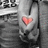 A grayscale image of a person holding hands with a red heart symbol on their chest, displayed in four