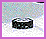 Pixelated black cylindrical object with white top on light gray background, transitioning to partial view of black curved shape.