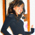 A pixelated static image shows a person with long dark hair wearing a black top, positioned between two vertical orange structures against a light background.