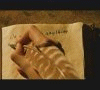 A sequence of animated frames showing a hand writing on parchment, then a boy holding a wand, and finally the parchment with handwritten text.