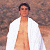A pixelated image of a person in a white robe standing against a textured brown background, with green text reading "Original Icons .com" on the right side.