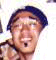 A person wearing a dark blue cap and light brown shirt with white background, showing facial expression changes