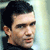 Pixelated static image of a man's face in profile view with dark hair and light skin tone against a gradient background.