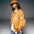Pixelated figure in orange cap and jacket, standing against gradient background with arms crossed.