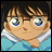 A pixelated anime-style character with brown hair and blue eyes in a light blue shirt with white collar, next to stylized text on black background.