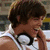 A six- of a person in a white tank top with headphones around their neck, showing sequential text overlays and facial expressions