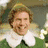 A pixelated image shows a person in a green outfit with a white collar on the left, and red text on purple shapes reading "buddy the elf. What's you favorite color?" on the right.