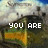 Pixelated image of a landscape with a yellow-orange structure under a cloudy sky, displaying text across three