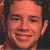 A 50x50 pixel animated buddy icon featuring a split composition with a person's face on the left and green text reading "Original Icons .com" on the right against a dark background.