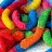 Colorful pixelated shapes in red, yellow, blue, green, and orange form a dense, overlapping pattern with no clear subject or text.