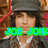 Pixelated image of a person with long brown hair wearing a dark cap and jacket, overlaid with colorful text and symbols.