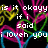 Pixelated text reads "is it okoyy if i said i love you" over a black background with colorful abstract pixel patterns in pink, yellow, green, and blue.