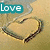 A heart-shaped sand drawing on a beach with changing text overlays in blue boxes.