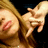 Pixelated close-up of a person with light brown hair, showing a partial face and hand gesture against a dark background.