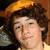A person with curly brown hair wearing a yellow cap and light-colored shirt appears in four , with one displaying pink text