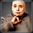 Pixelated static image of a bald figure in dark clothing holding an object with red and black details against a gray background.