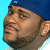 Pixelated close-up of a person's face with blue background, showing partial head and ear in low-resolution static image.