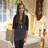 A pixelated static image shows a person with long brown hair wearing dark clothing against a blurred background of warm tones and indistinct shapes.