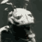 Animated sequence of a stylized insectoid figure with segmented body, antennae, and dark torso against gray background showing head movement from left to right.